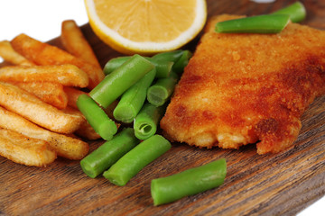 Breaded fried fillet and potatoes with asparagus and sliced