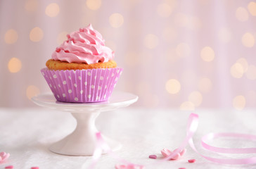 Sweet cupcake on table on light background