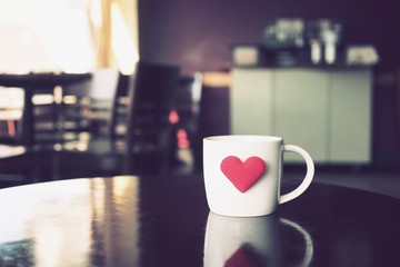 vintage color tone of  cup of coffee with red heart on the table