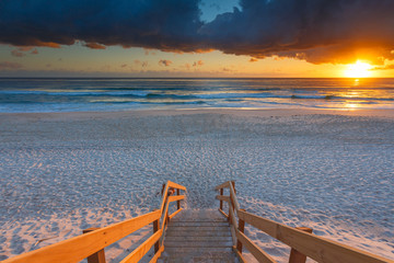 Australian beach entry with stairs in foreground at sunrise