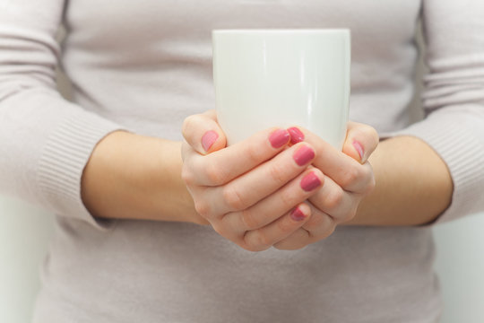 Woman hands holding white cup of  tea or coffe