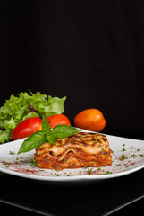 Lasagna on a square white plate