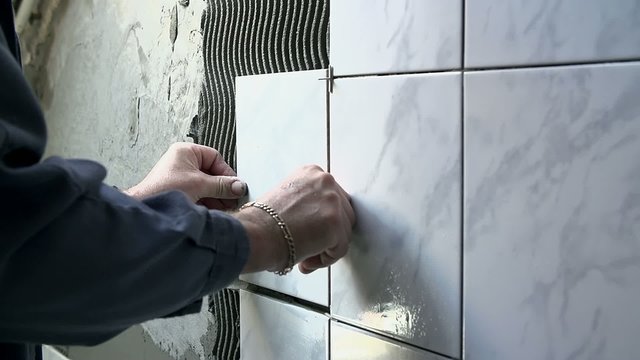 Ceramist puts tile on the wall
