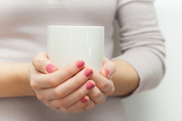 Woman hands holding white cup of tea or coffe