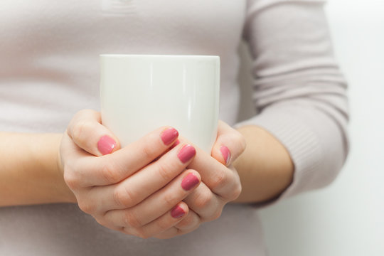 Woman hands holding white cup of tea or coffe