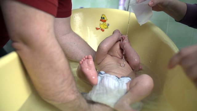 Parents giving their baby a bath 
