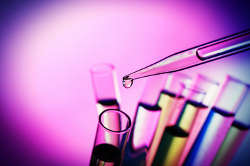 Pipette adding fluid to the one of test-tubes © Africa Studio