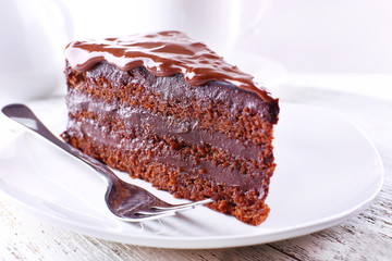 Delicious chocolate cake on plate on table on light background