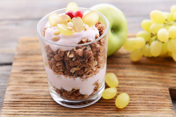 Healthy layered dessert with muesli and berries on table