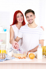 Obraz na płótnie Canvas Happy couple cooking in kitchen