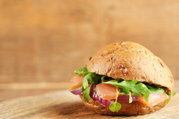 Sandwich with salmon on wooden background