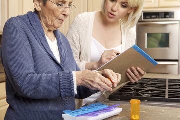 Senior Women Getting Help Organizing Her Prescription Medicine