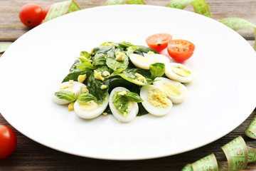 Salad with quail egg and basil in plate with measuring tape