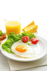 Bacon and eggs on color wooden table background