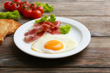 Bacon and eggs on rustic wooden planks background