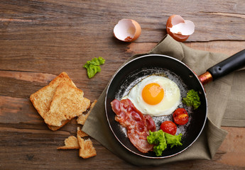 Bacon and eggs on rustic wooden planks background