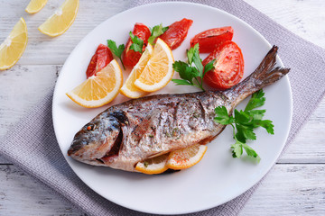 Tasty baked fish on table close-up