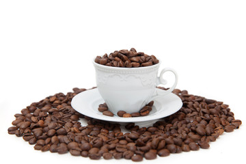 The white mug full of coffee beans isolated on white background