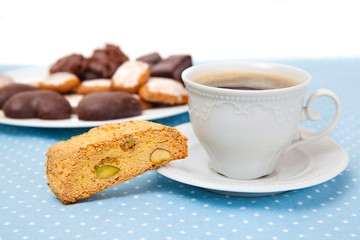 The cup of black coffee with cookie and chocolate sweets