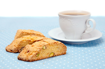 The  cup of coffee with cookies on blue tablecloth