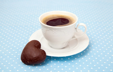 Cup of espresso and chocolate cookies in the shape of a heart