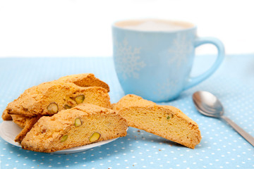 The big cup of hot beverage with cookies on blue tablecloth