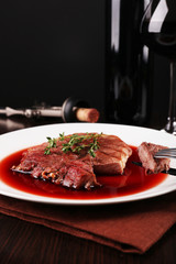 Grilled steak in wine sauce with glass of wine