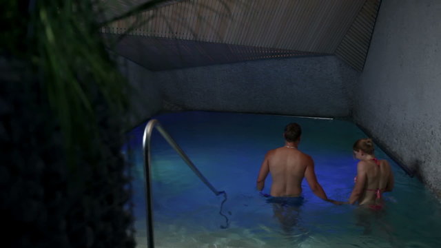 HD shot of a couple enjoying in a colorful swimming pool