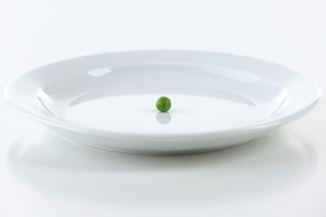 One pea on plate isolated on white
