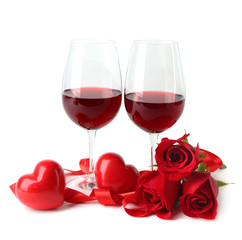 Composition with red wine in glasses, red roses, ribbon and