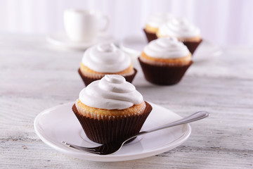 Delicious cupcakes on table on light background