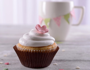 Delicious cupcake on table on light background