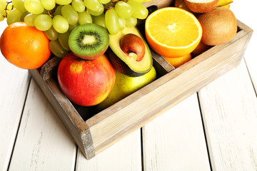 Assortment of fruits in box on wooden table