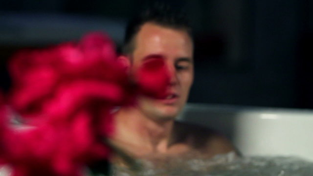 red roses and young couple in jacuzzi spending romatic time together