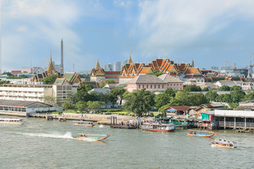 Obraz premium Grand palace with long tail boat in Chao Phraya River in Bangkok