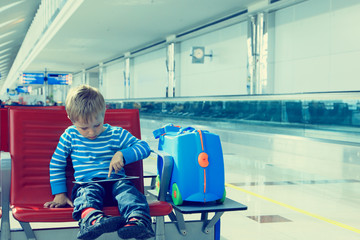 little boy with touch pad waiting in the airport