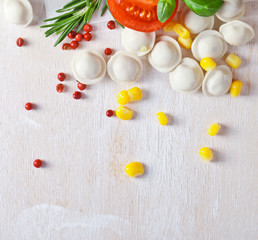 Fototapeta na wymiar Tortellini and vegetables on white wooden background