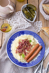Mashed potatoes with apples served with sausages and bacon