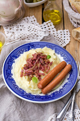 Mashed potatoes with apples served with sausages and bacon