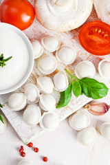 Tortellini and vegetables on white wooden background