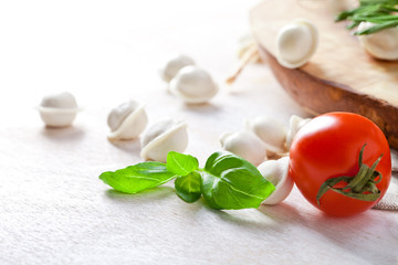 Obraz na płótnie Canvas Tortellini and vegetables on white wooden background
