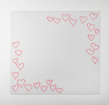 White empty board, with hand-drawn red hearts, on white wall