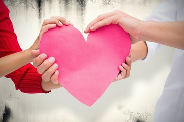 Obraz premium Composite image of couple holding a heart