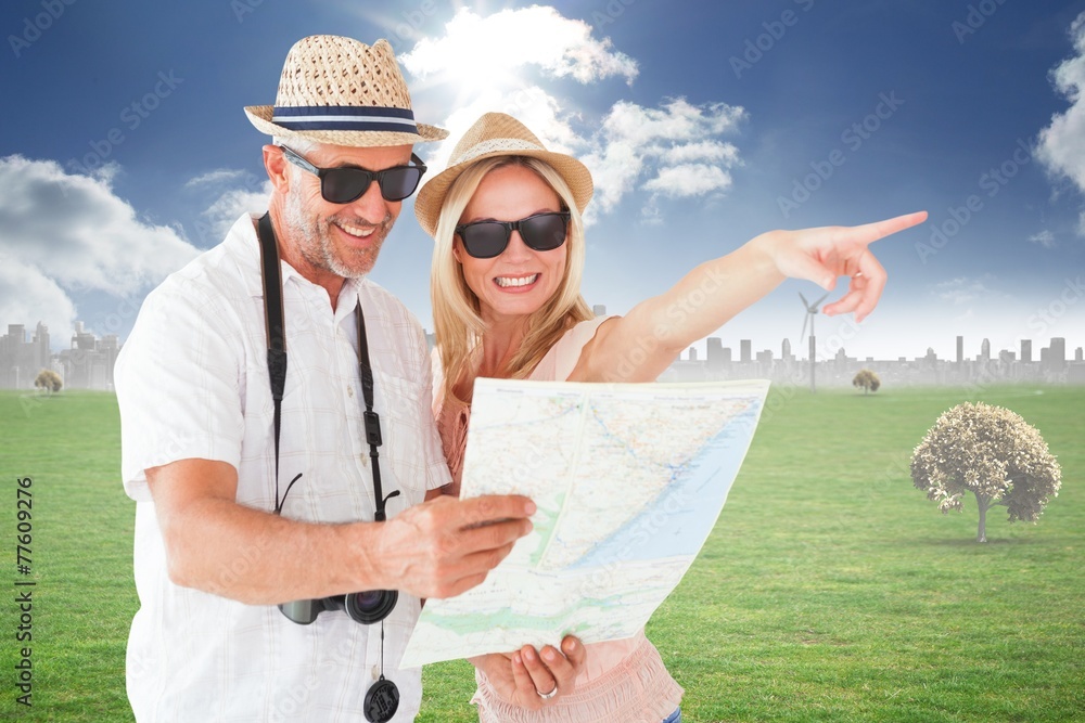 Aufkleber Composite image of happy tourist couple using map and pointing