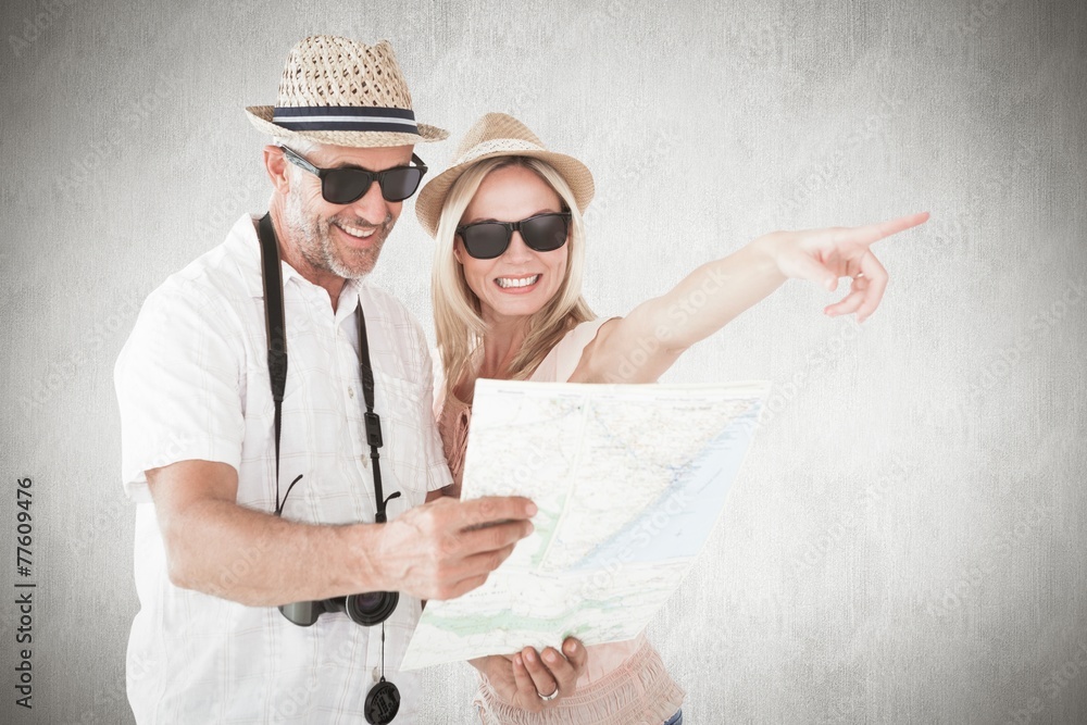 Aufkleber Composite image of happy tourist couple using map and pointing
