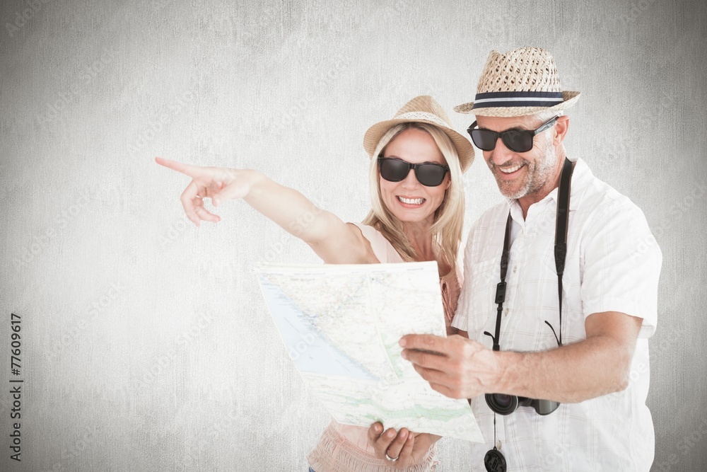 Aufkleber Composite image of happy tourist couple using map and pointing