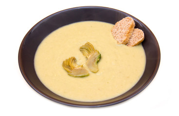 Cream of artichokes and croutons on a white background