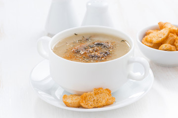 delicious mushroom cream soup with croutons on white table