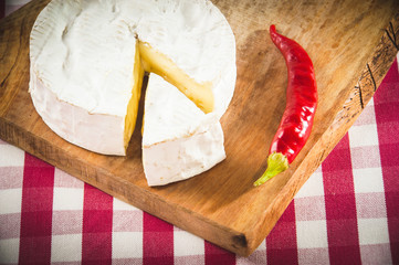 Smelly camembert cheese on a wooden rustic table