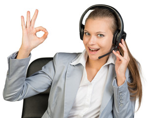 Businesswoman in headset making okay gesture